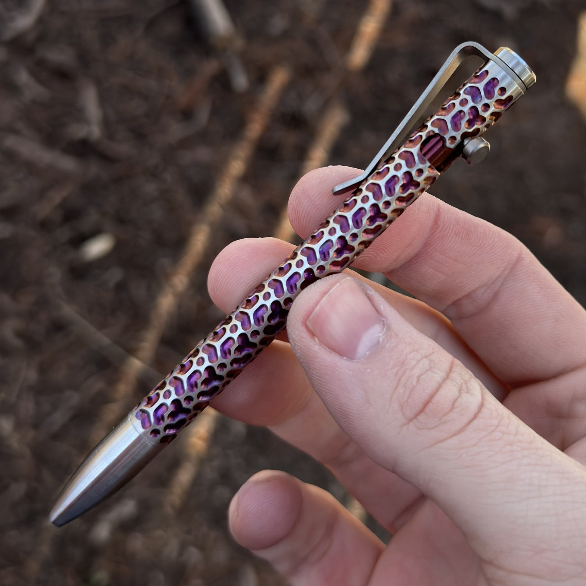 A person grasping a pen featuring a purple design, showcasing creativity and artistic flair.